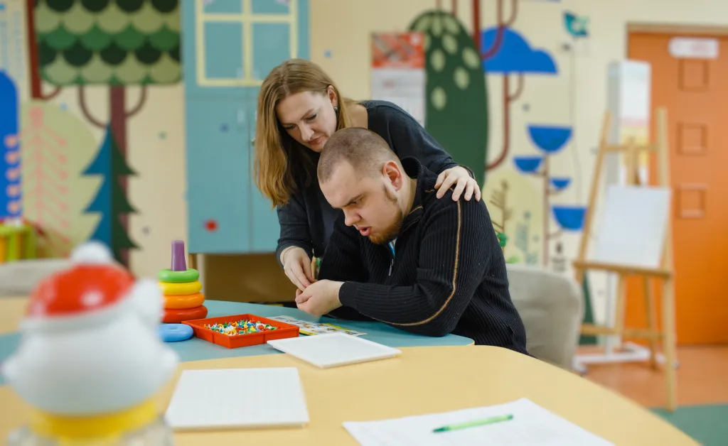 A female psychologist works with an autistic adult in her office.