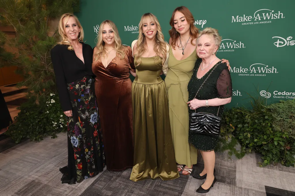 Five women pose together on a green carpet at the Make-A-Wish Foundation Gala.