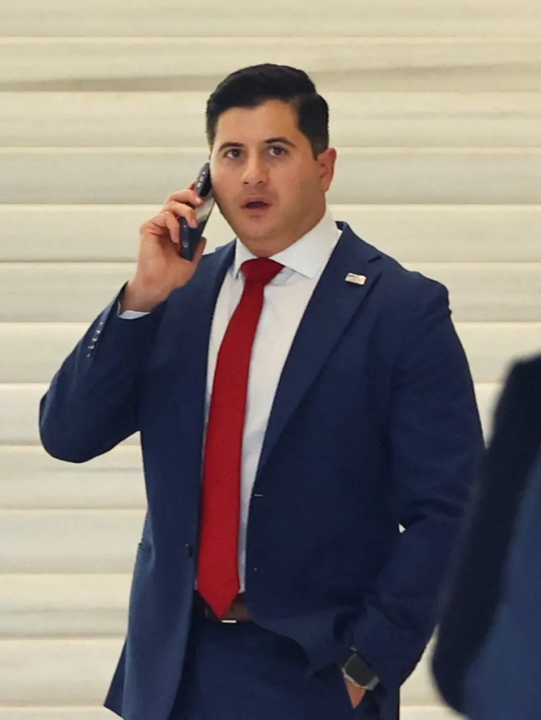 Bill Essayli, First Assistant U.S. Attorney, speaks on a cell phone inside a courthouse.