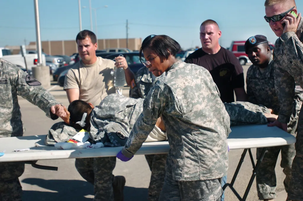 First responders use a table as a stretcher to transport a wounded soldier.