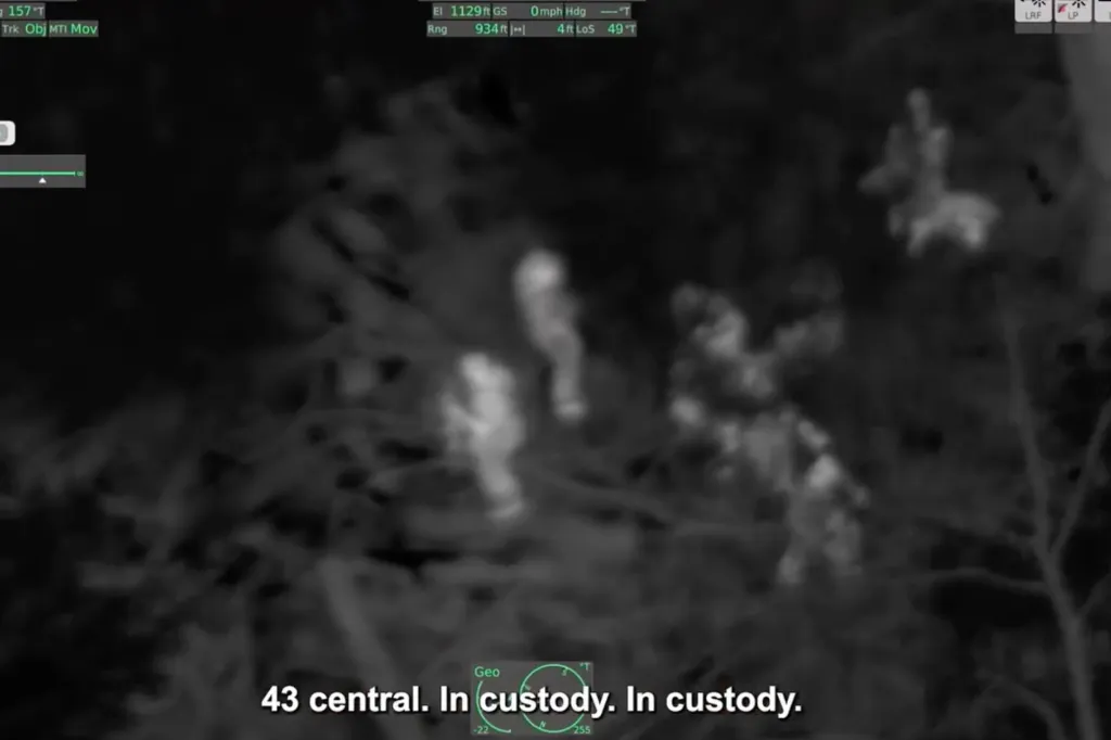 FLIR camera aerial view of a suspect hiding under debris in the woods, with police officers closing in.