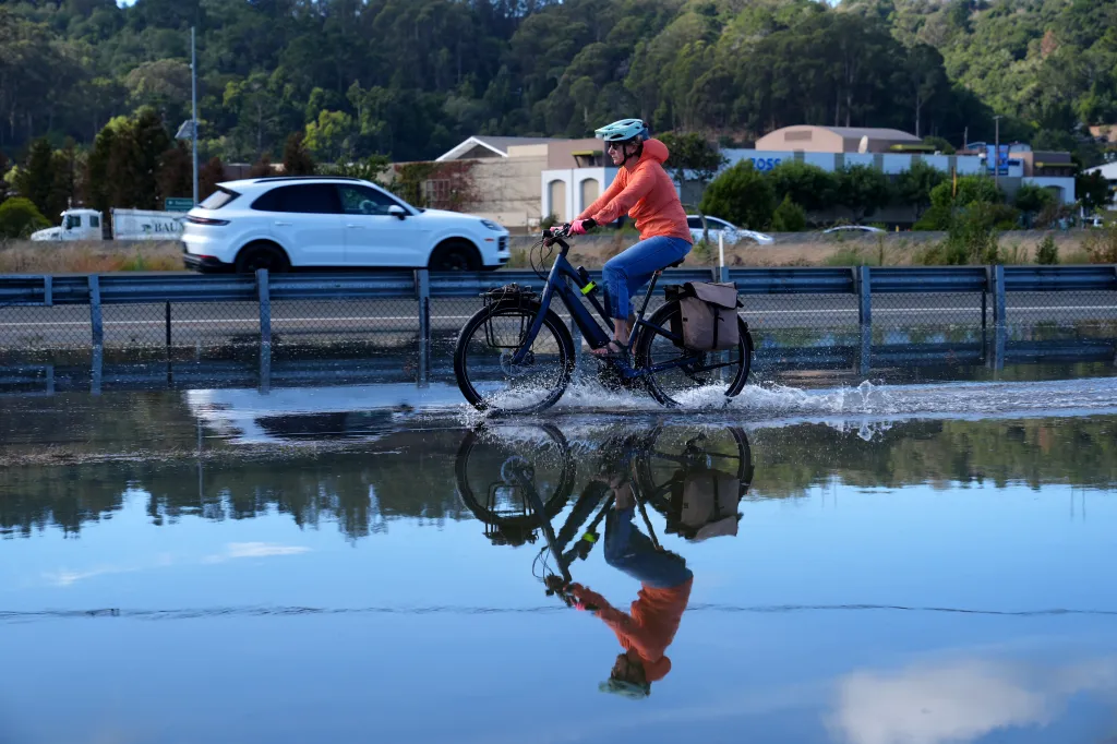 A biker rides along a flooded trail between Sausalito and Mill Valley, California, during high tide.