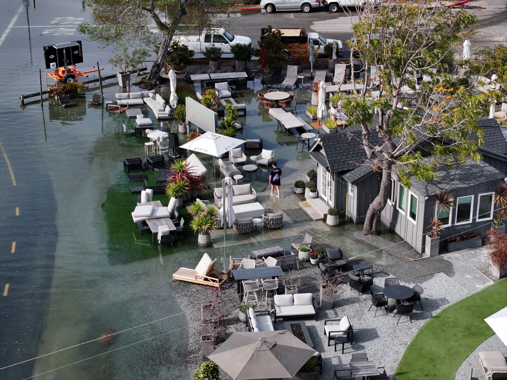 Floodwaters cover roads and outdoor seating areas in Mill Valley, California, during a high tide.