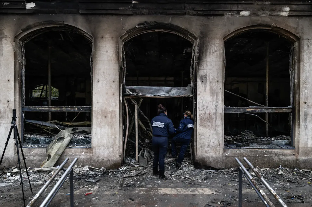 Forensic officers examine the burnt Lyon Office de Tourisme after rioting and looting in Lyon, France.
