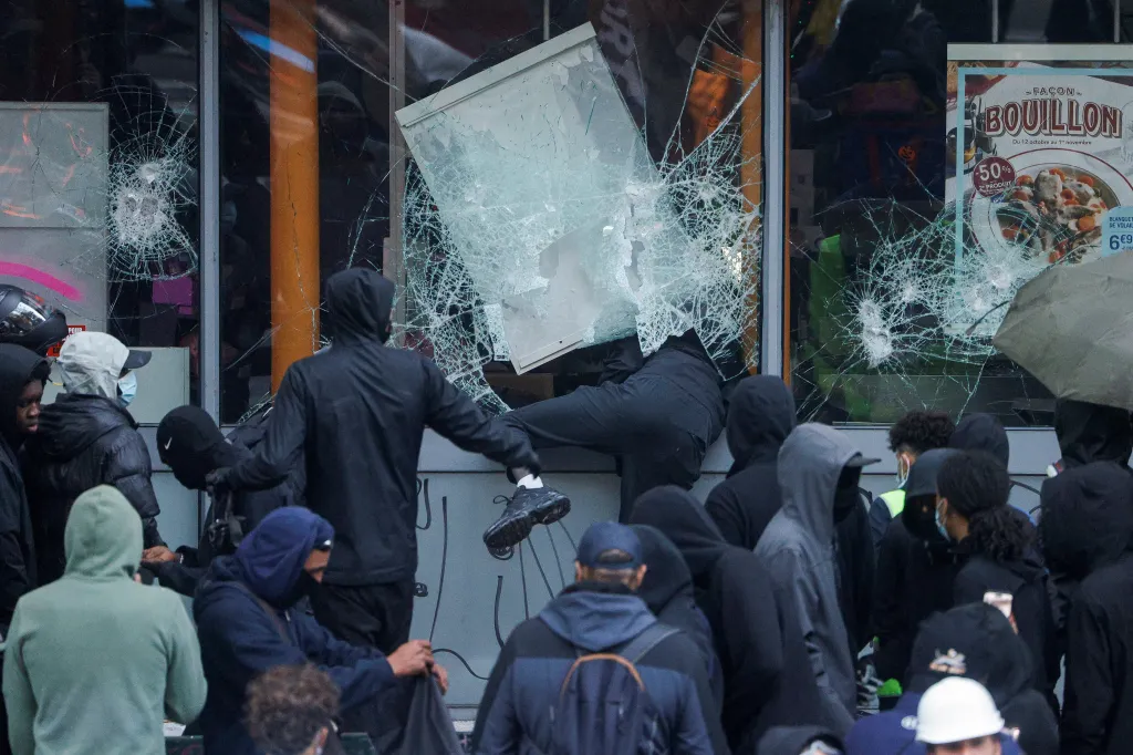 Protesters break windows of a Picard shop during a demonstration against the high cost of living in Paris.