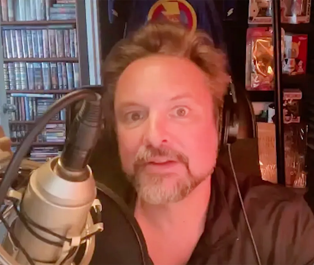 Will Friedle wearing headphones in front of a microphone.
