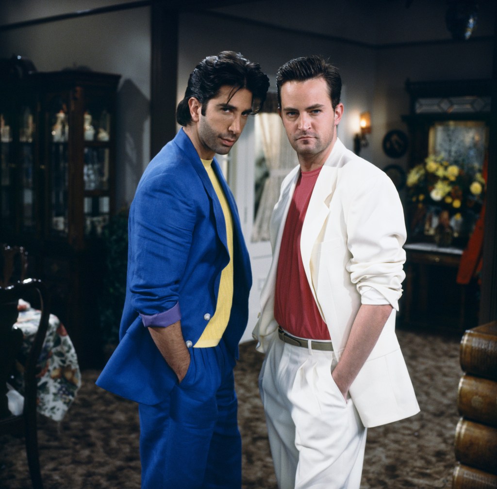 David Schwimmer as Ross Geller and Matthew Perry as Chandler Bing dressed in retro pastel 1980s-style suits in an episode of Friends.