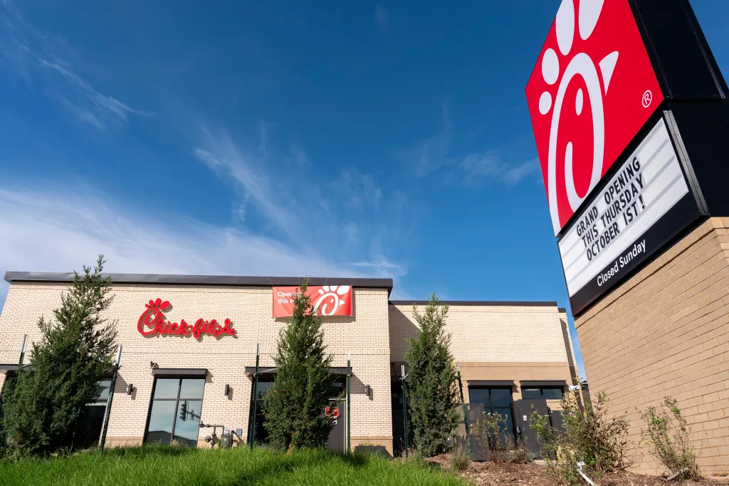 Exterior view of the Chick-fil-A restaurant in Coralville, Iowa, featuring its entrance, signage, and landscaping under a clear blue sky.
