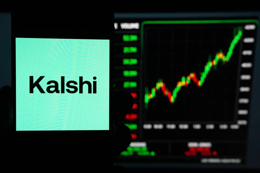 The Kalshi logo displayed on a smartphone with a financial chart in the background.