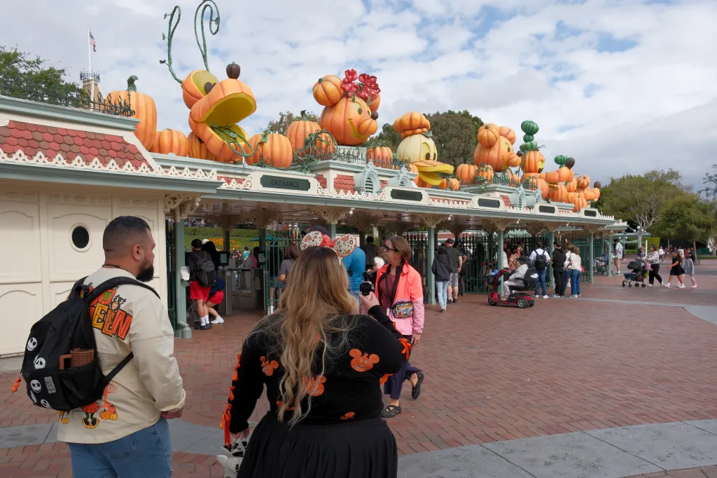 The entrance to Disneyland decorated with oversized character pumpkins.