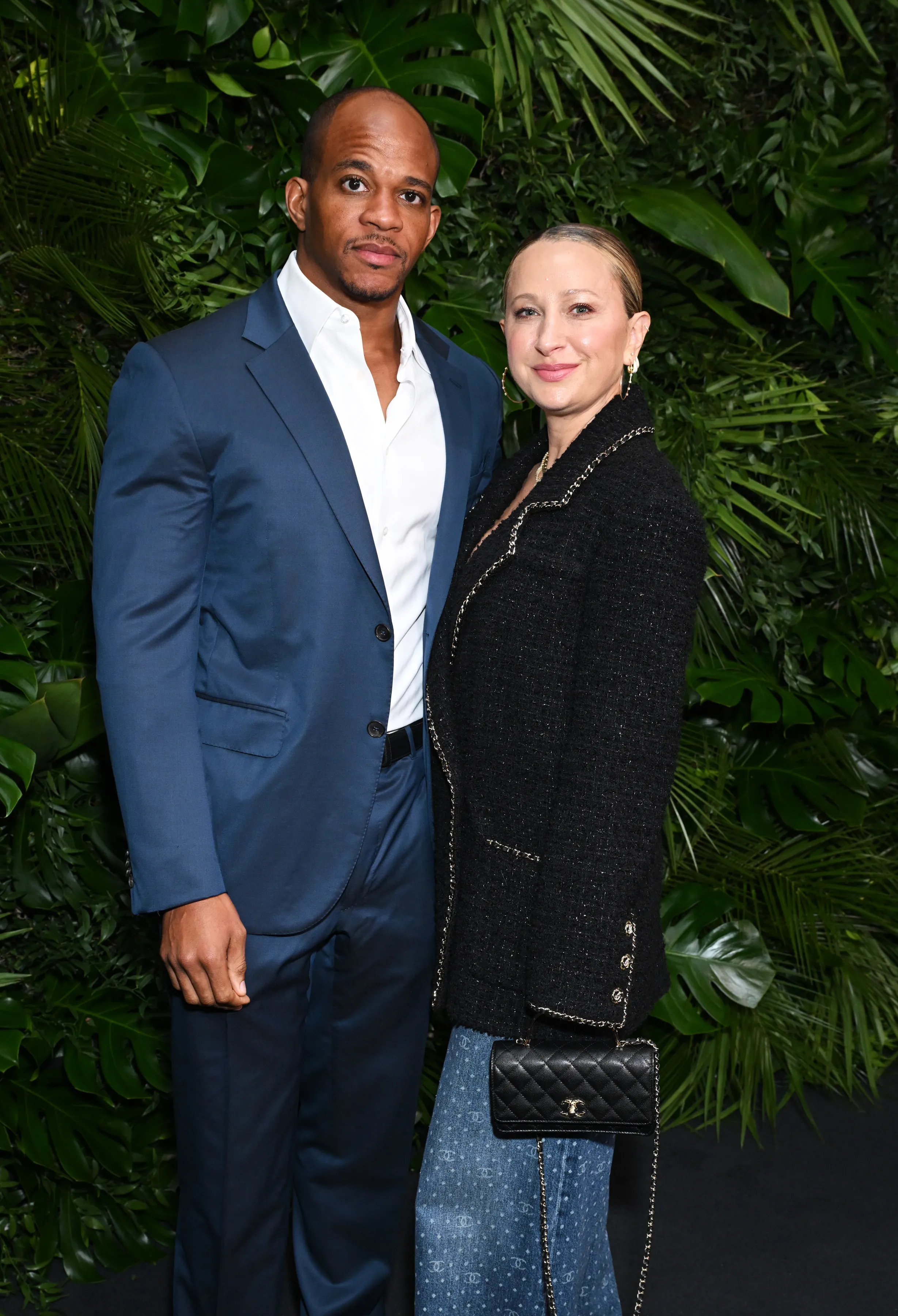 Geoffrey Ogunlesi and Jennifer Meyer stand side by side against a leafy green background.