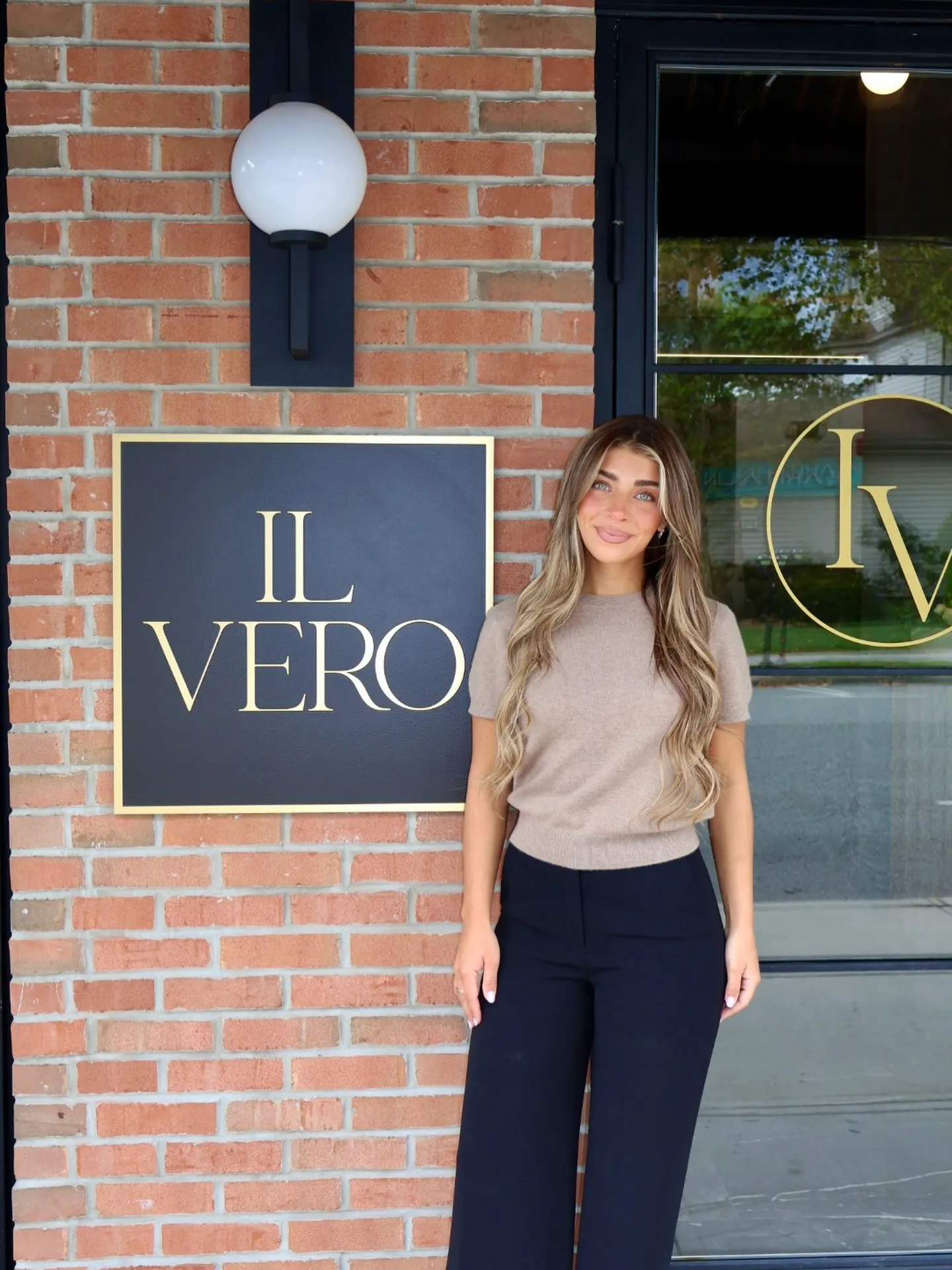 Gia Giudice standing in front of the Il Vero restaurant sign.
