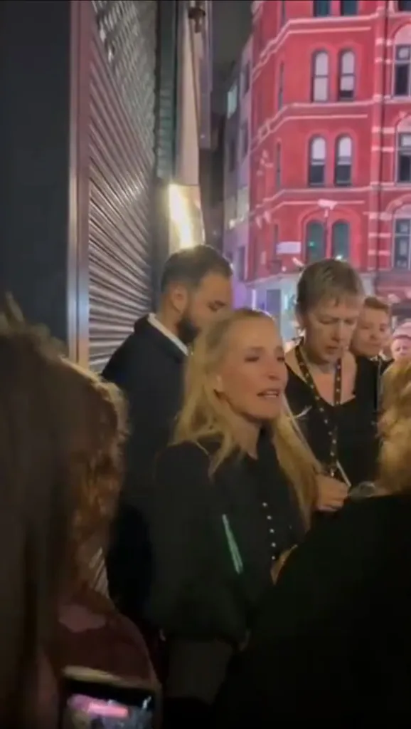Gillian Anderson outside at night surrounded by people.