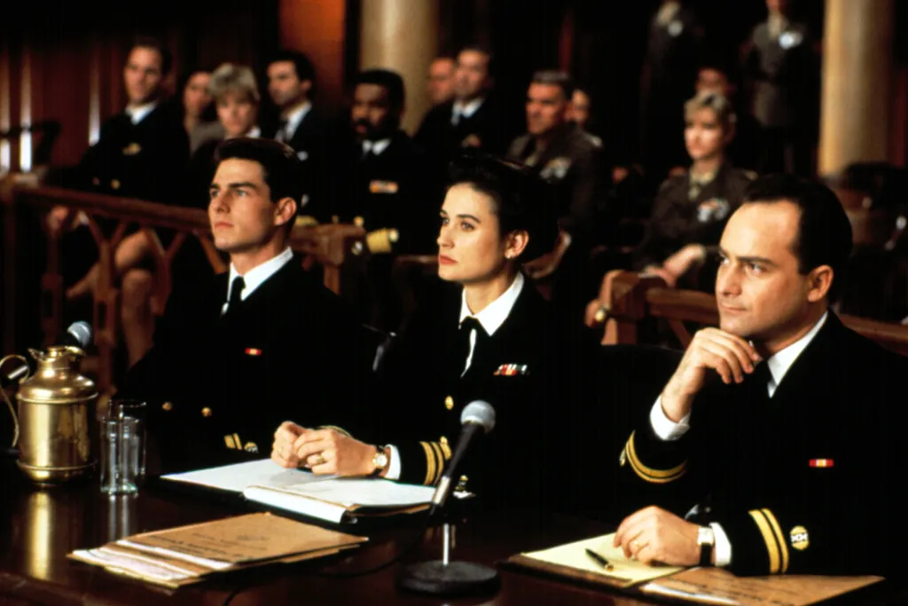 Film still of Tom Cruise, Demi Moore, and Kevin Pollak sitting at a defense table in a courtroom.