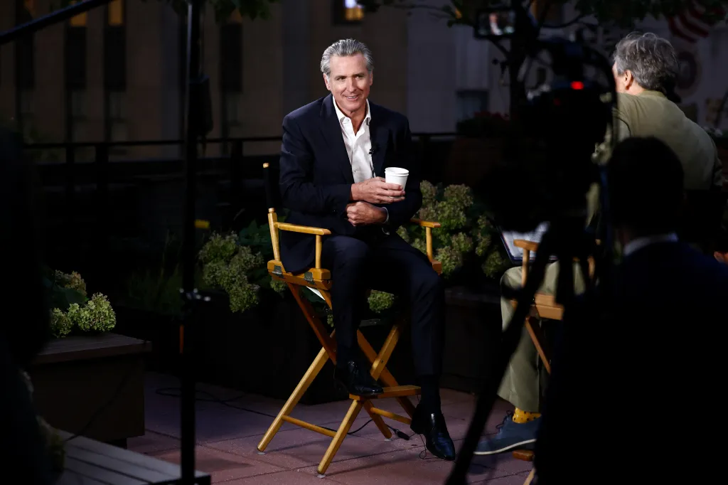 California Governor Gavin Newsom sits in a director's chair during an interview in New York City.