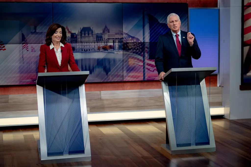 Gov. Kathy Hochul and Republican challenger Bruce Blakeman at podiums during a debate.