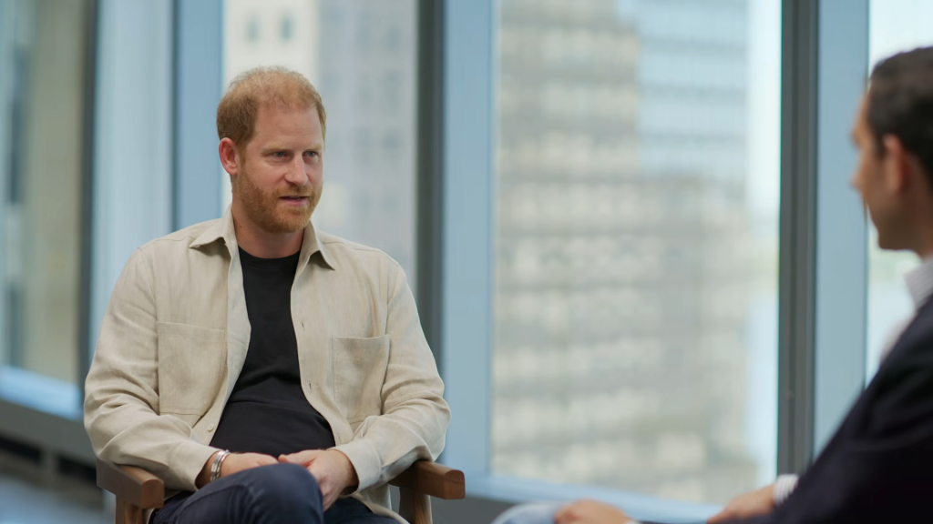 Prince Harry sitting in a chair during an interview.
