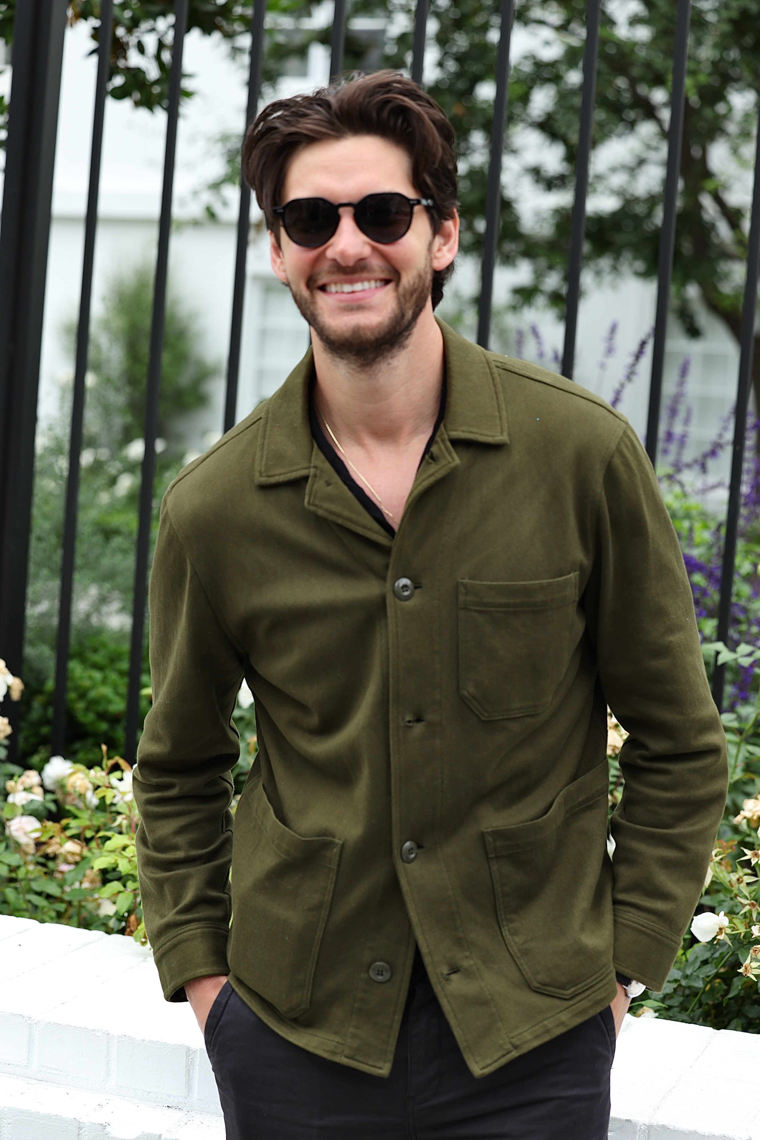 Actor Ben Barnes wearing sunglasses and an olive green jacket.