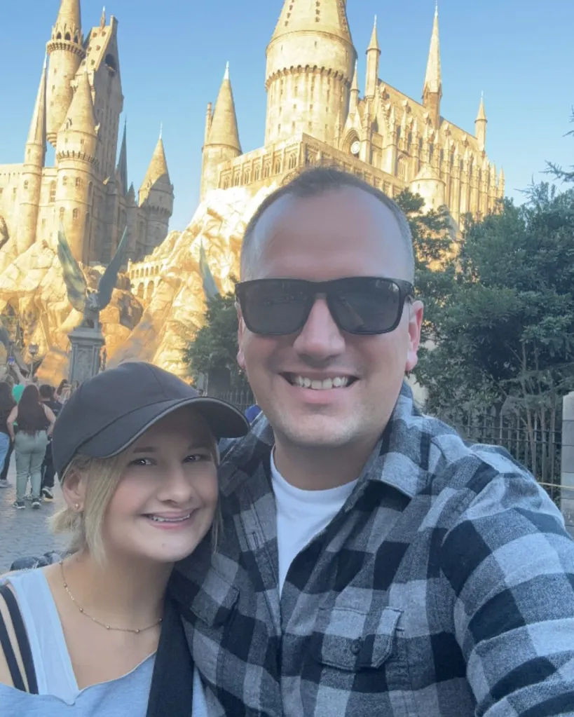 Gypsy Rose Blanchard and Ken Urker posing for a selfie in front of Hogwarts Castle.