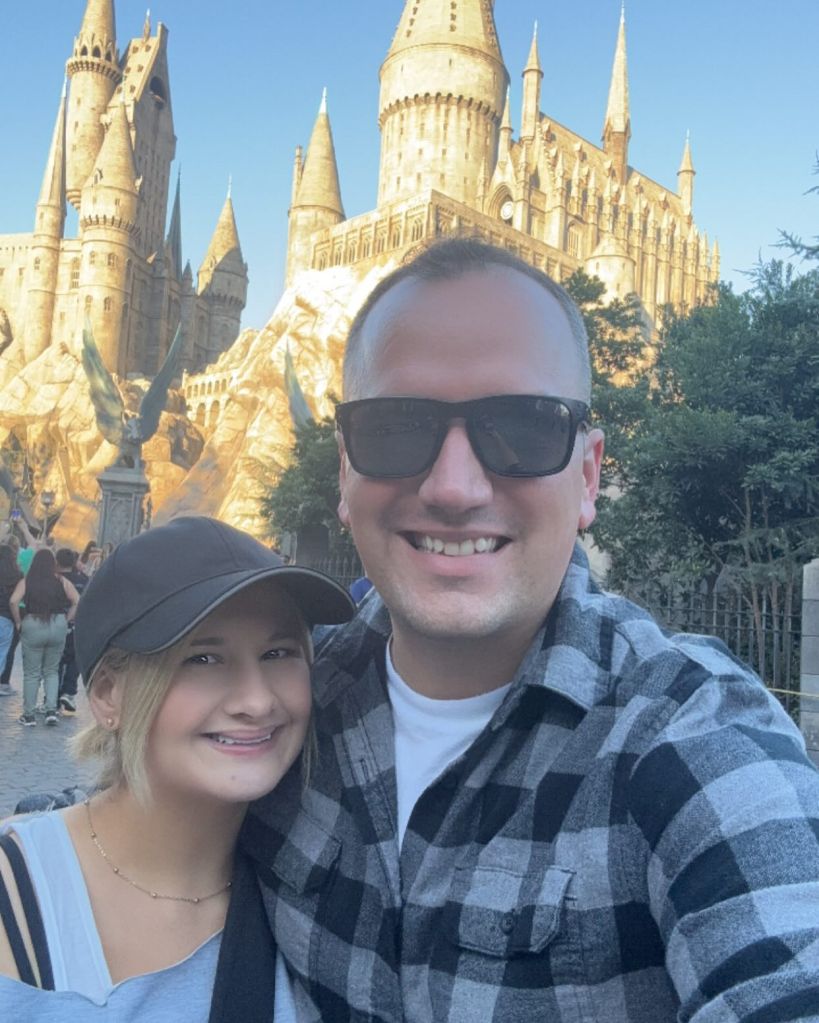 Gypsy Rose Blanchard and Ken Urker posing for a selfie in front of the Hogwarts castle.
