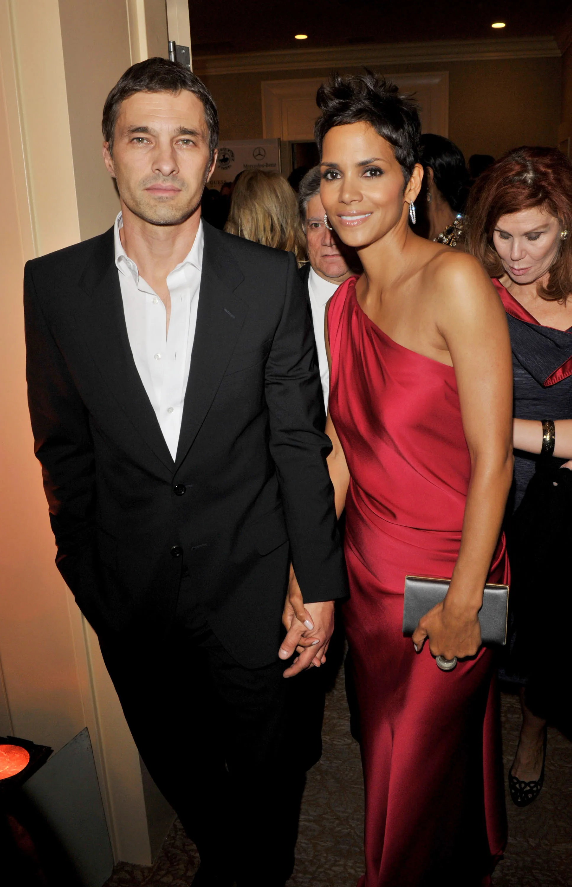Halle Berry and Olivier Martinez holding hands at an event.