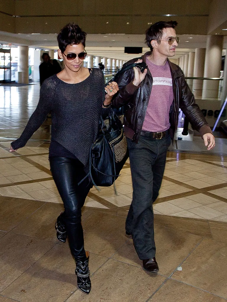 Halle Berry and Olivier Martinez walking through an airport terminal.