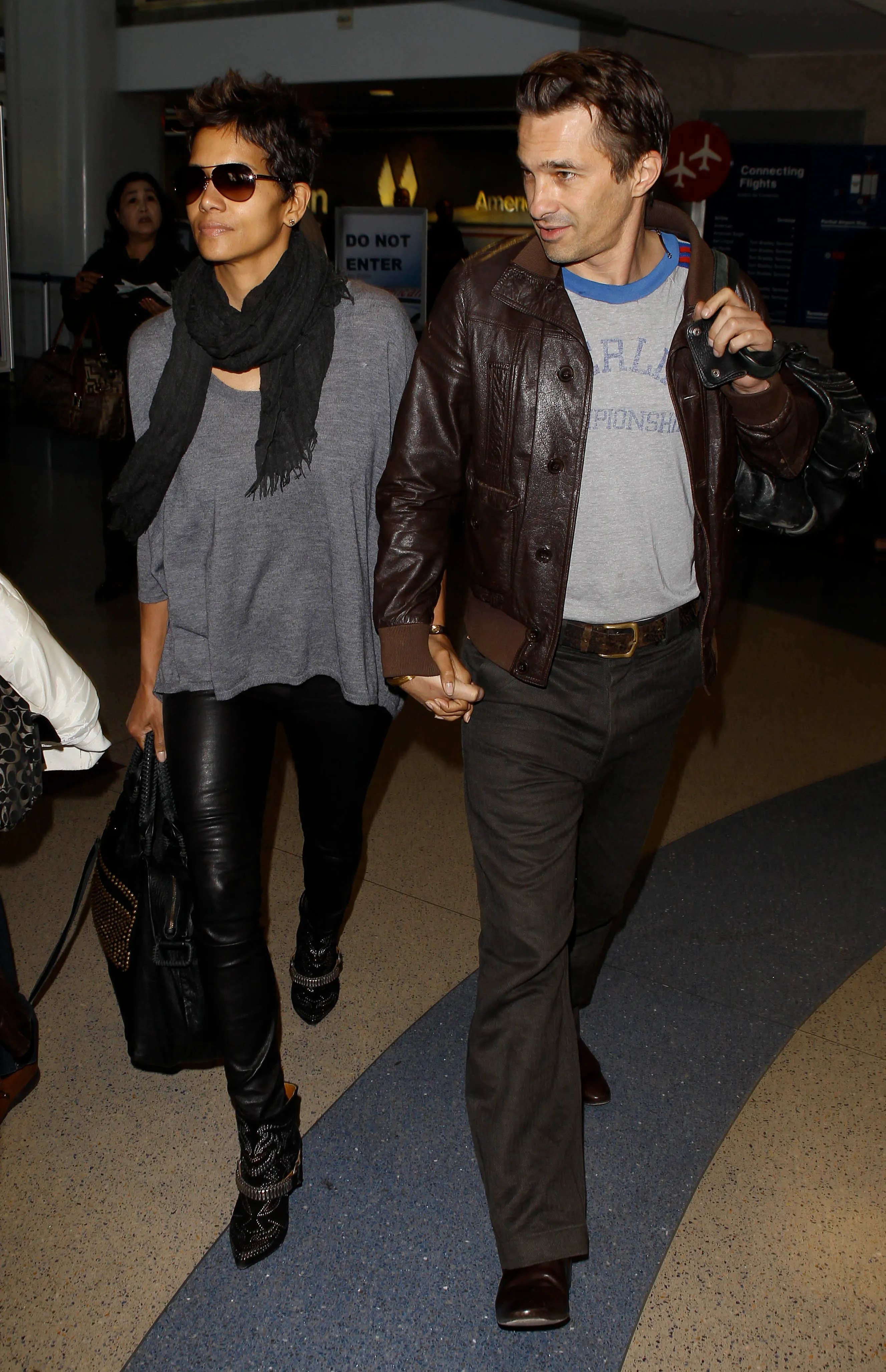 Halle Berry and Olivier Martinez walking hand-in-hand in an airport.