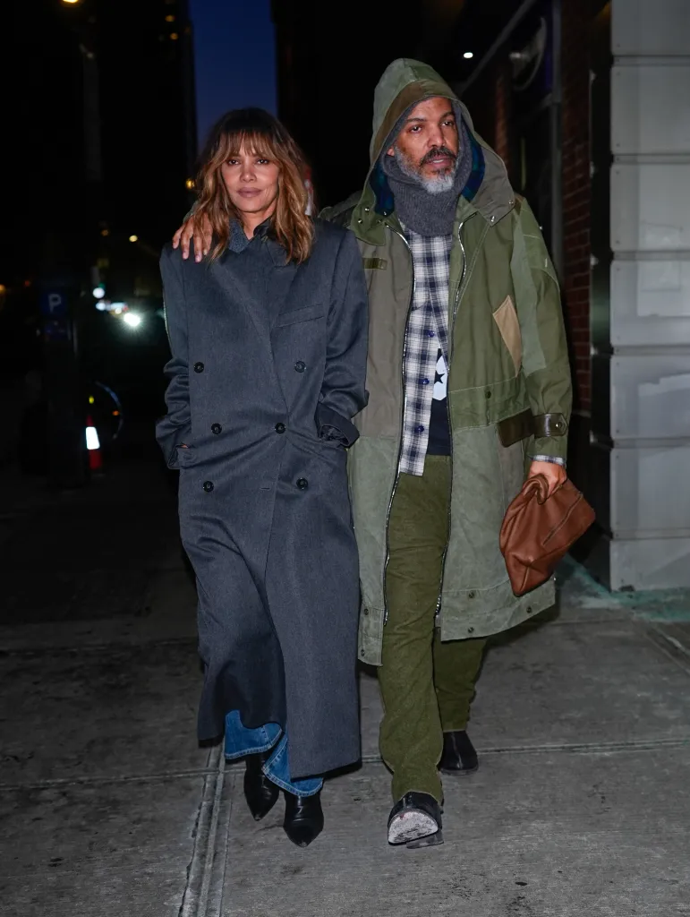 Halle Berry and Van Hunt walking together outdoors at night.