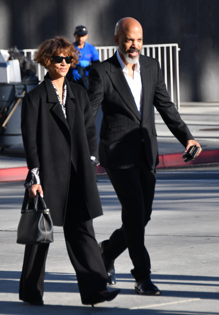 Halle Berry and Van Hunt walking outdoors, both dressed in black.