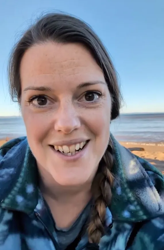 Hannah Damon smiling while exploring the shoreline at Camp Amnicon in South Range, Wisconsin.