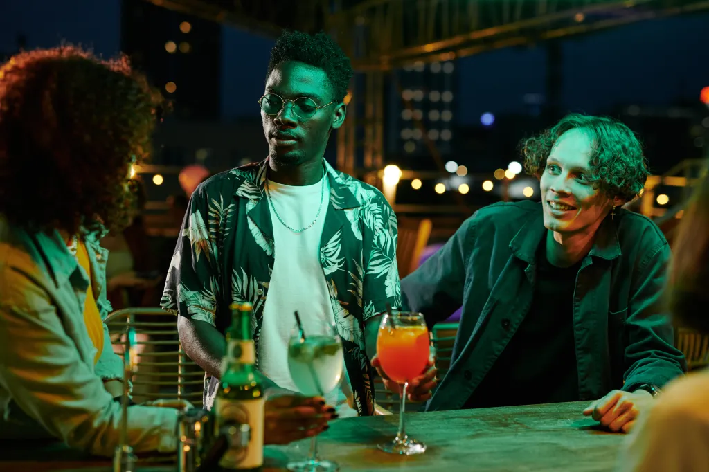 Happy young friends enjoying a drink at a bar