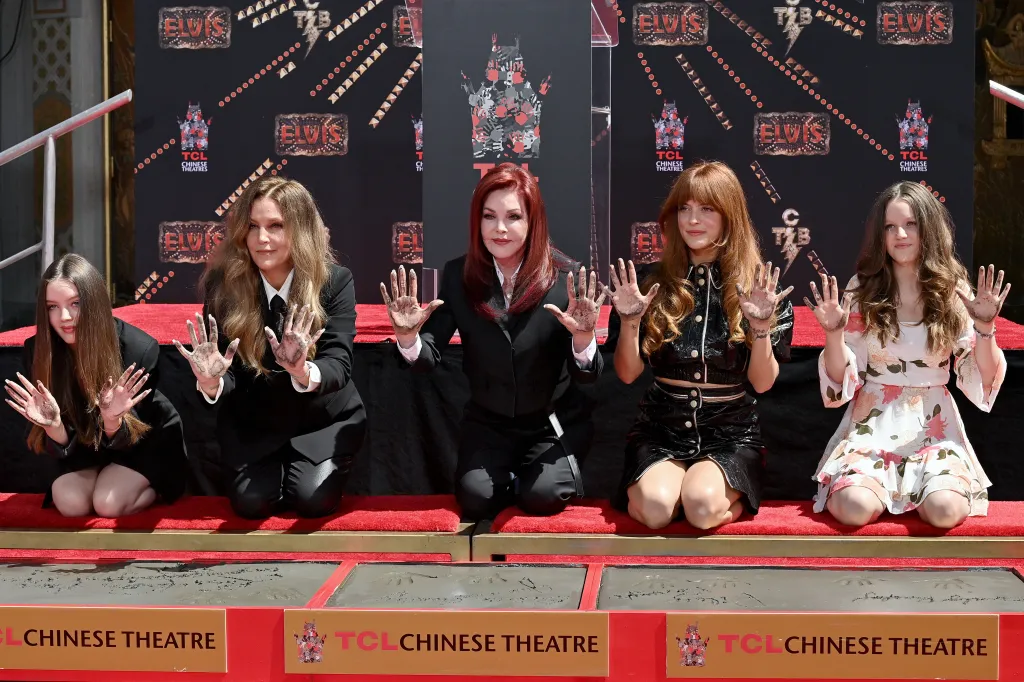 Harper Vivienne Ann Lockwood, Lisa Marie Presley, Priscilla Presley, Riley Keough, and Finley Aaron Love Lockwood pose with their hands covered in cement during a handprint ceremony at the TCL Chinese Theatre.