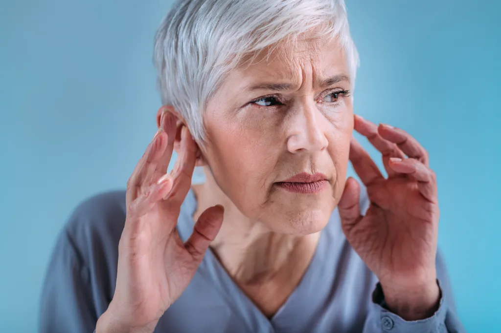 A senior woman with symptoms of hearing loss.