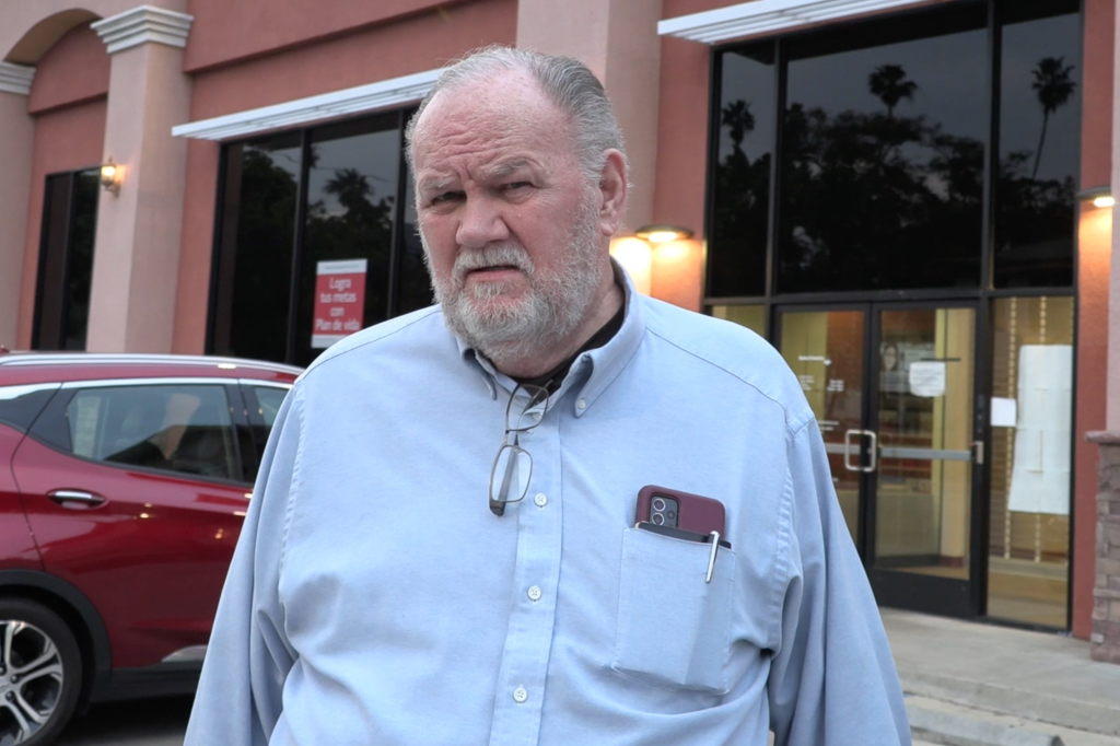 Thomas Markle stands outside a building in a light blue shirt.