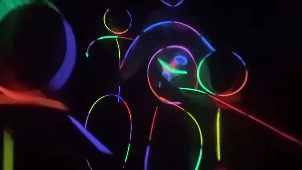 People wearing glow sticks in the dark, forming stick figures.