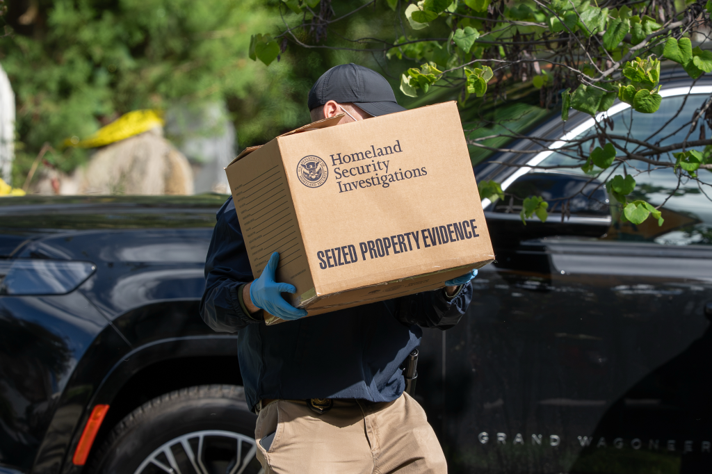 Homeland Security officer carrying a box labeled 
