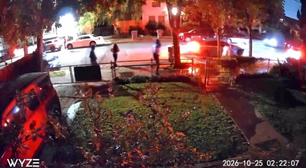 Surveillance camera footage of people fleeing outside a house during a shooting.