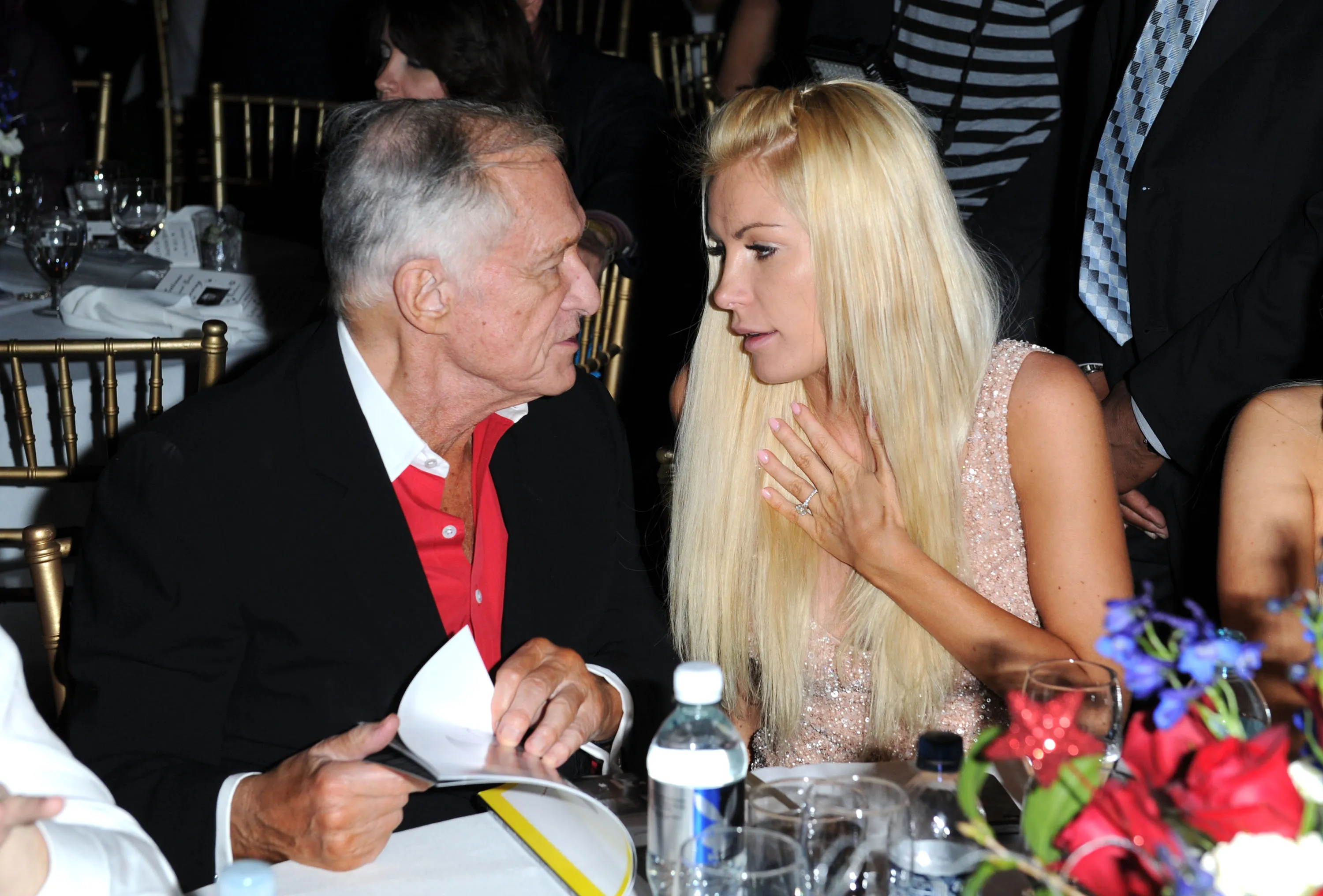 Hugh Hefner and Crystal Harris seated together at a gala.