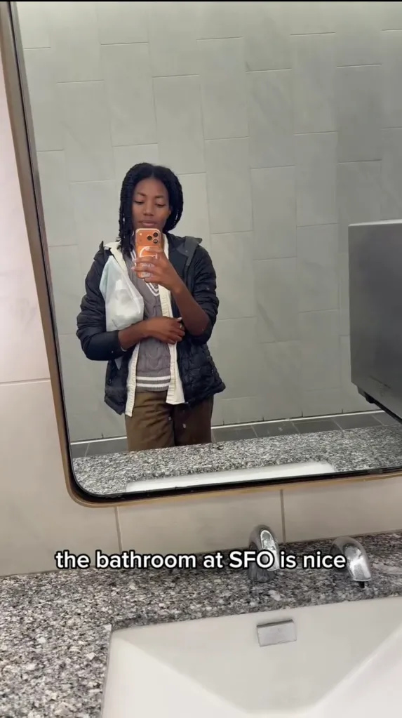 Santeon Brown taking a mirror selfie in an airport bathroom with the caption 