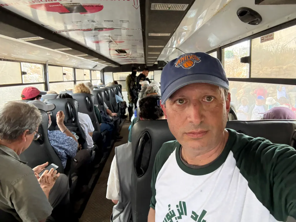 Brad Lander taking a selfie inside a crowded bus with other detained individuals.