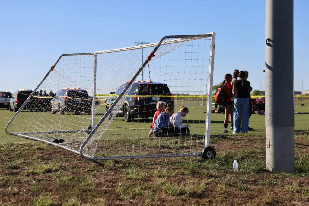 Police on the scene where a person drove a vehicle through a soccer field during a game.