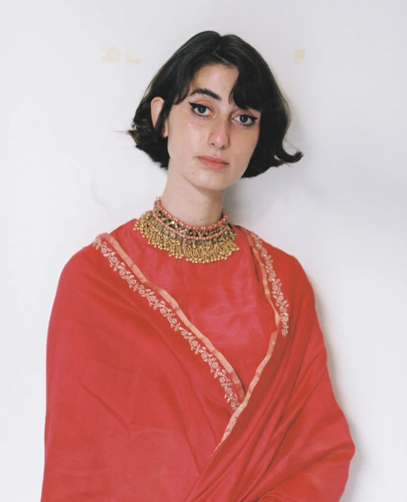 Rama Duwaji wearing a red outfit and gold necklace.
