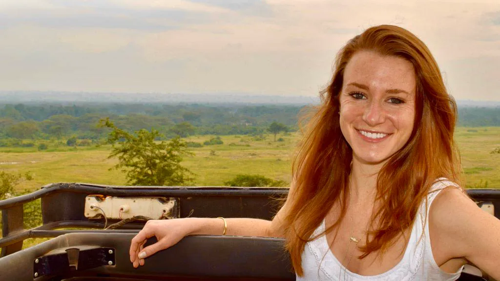 Kristin Knouse posing on a safari vehicle overlooking a landscape.