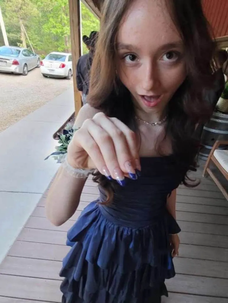 Persephone Berger, 16, smiling while wearing a dark dress.