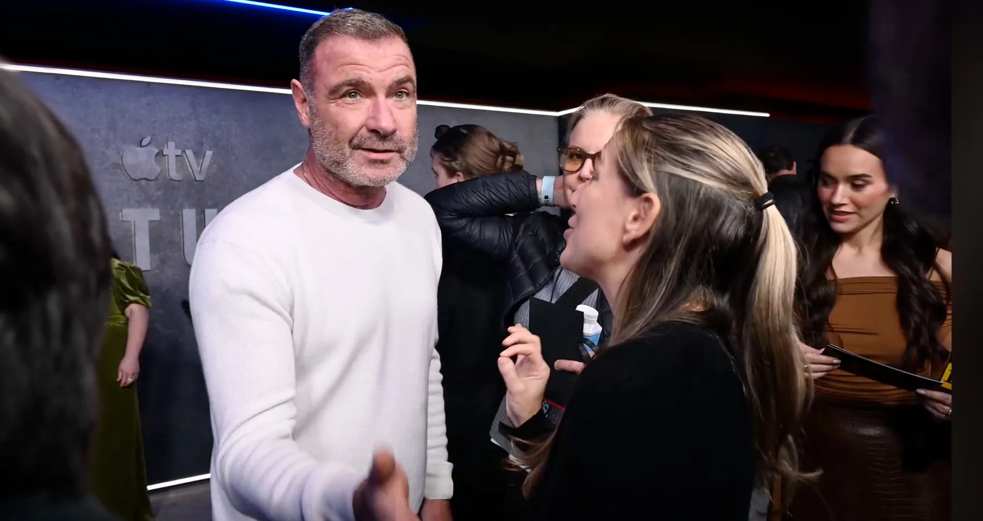 Liev Schreiber having a heated exchange with a reporter on a red carpet.