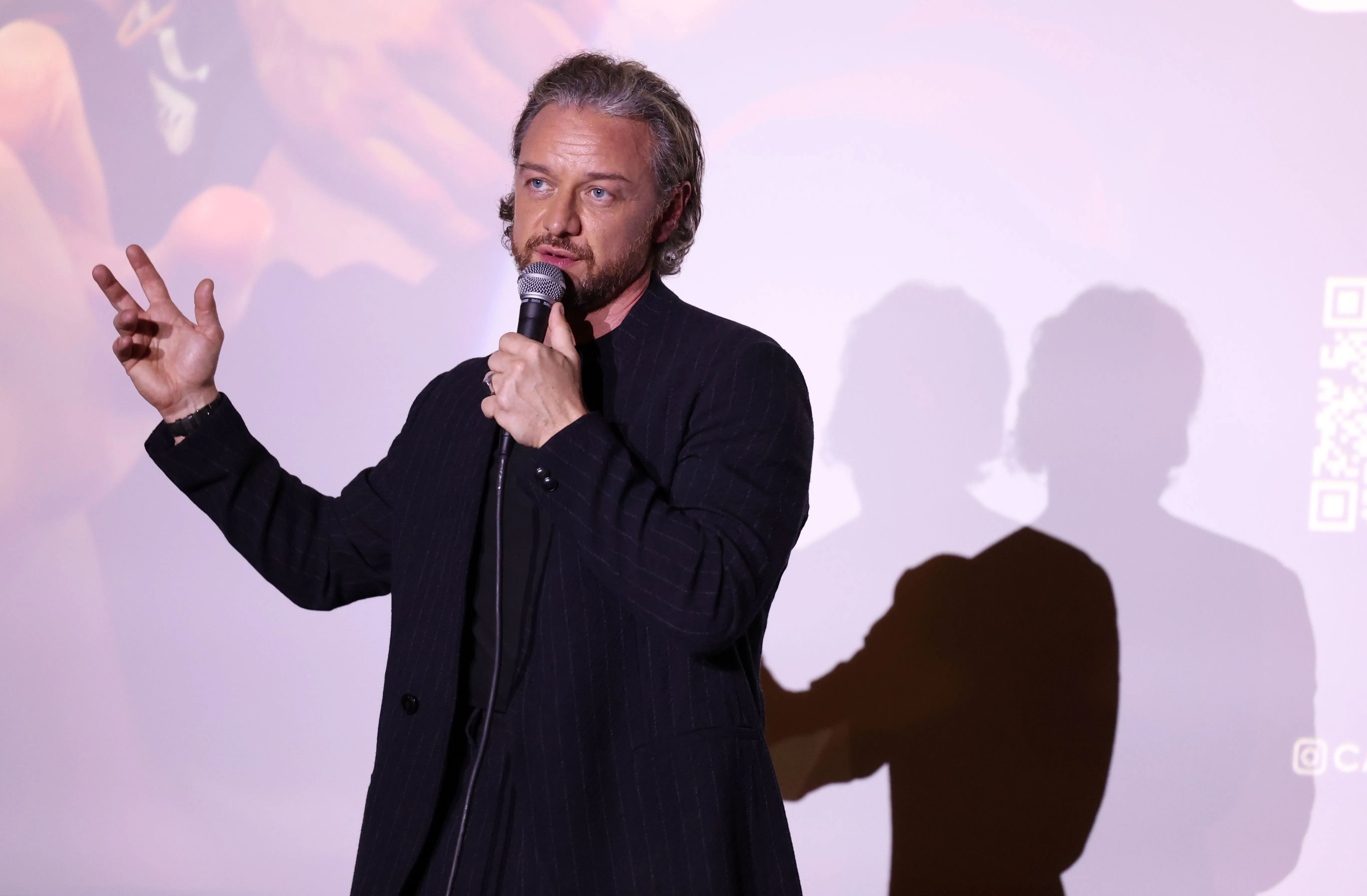 James McAvoy speaks into a microphone at a special screening of 'California Schemin''.