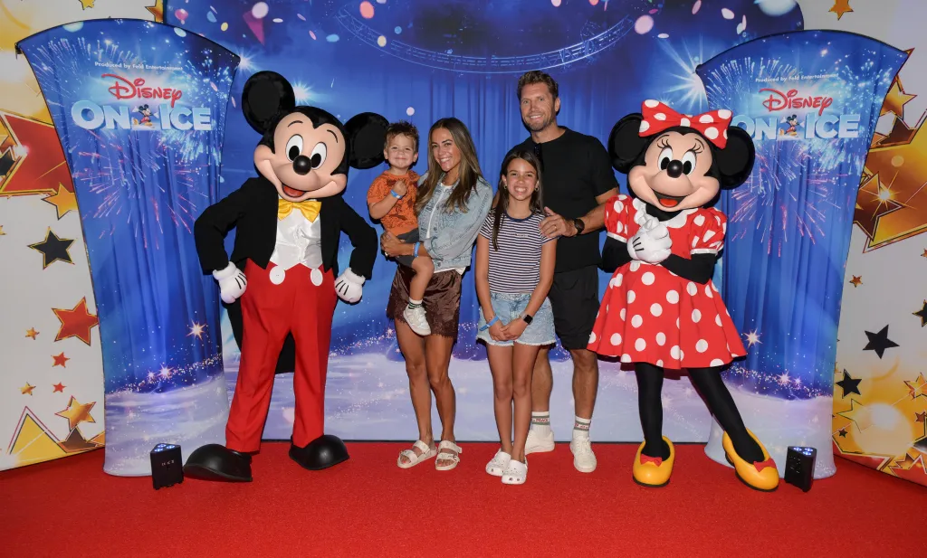 Jana Kramer, Allan Russell, and their family pose for a photo with Mickey Mouse and Minnie Mouse at a Disney On Ice event.
