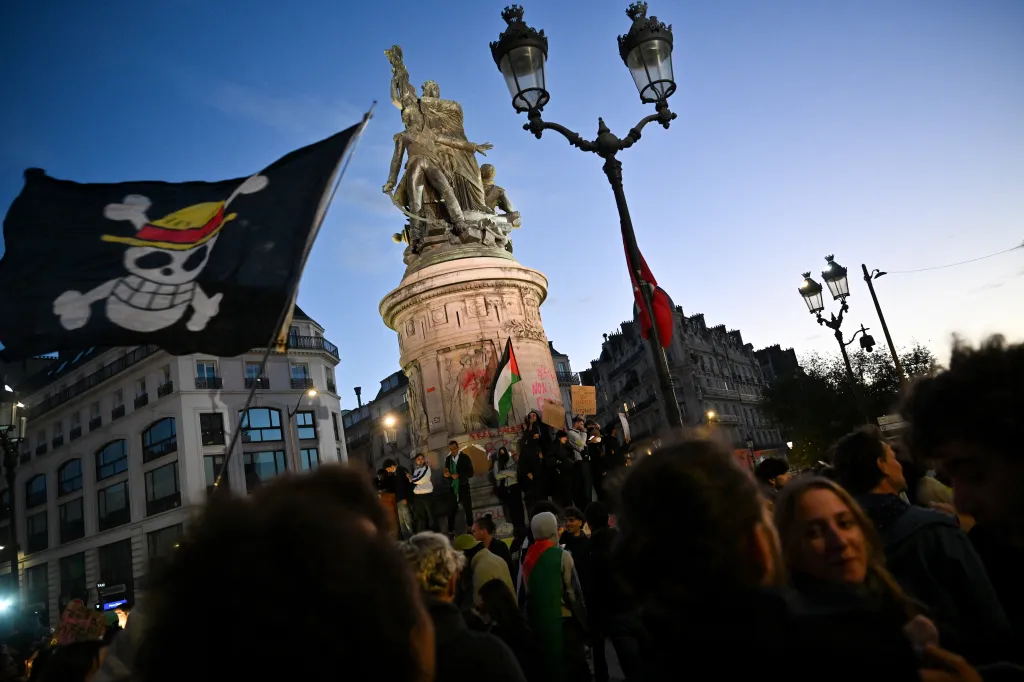A protester holds a One Piece flag in front of the Monument to Marechal Moncey during a demonstration in Paris.