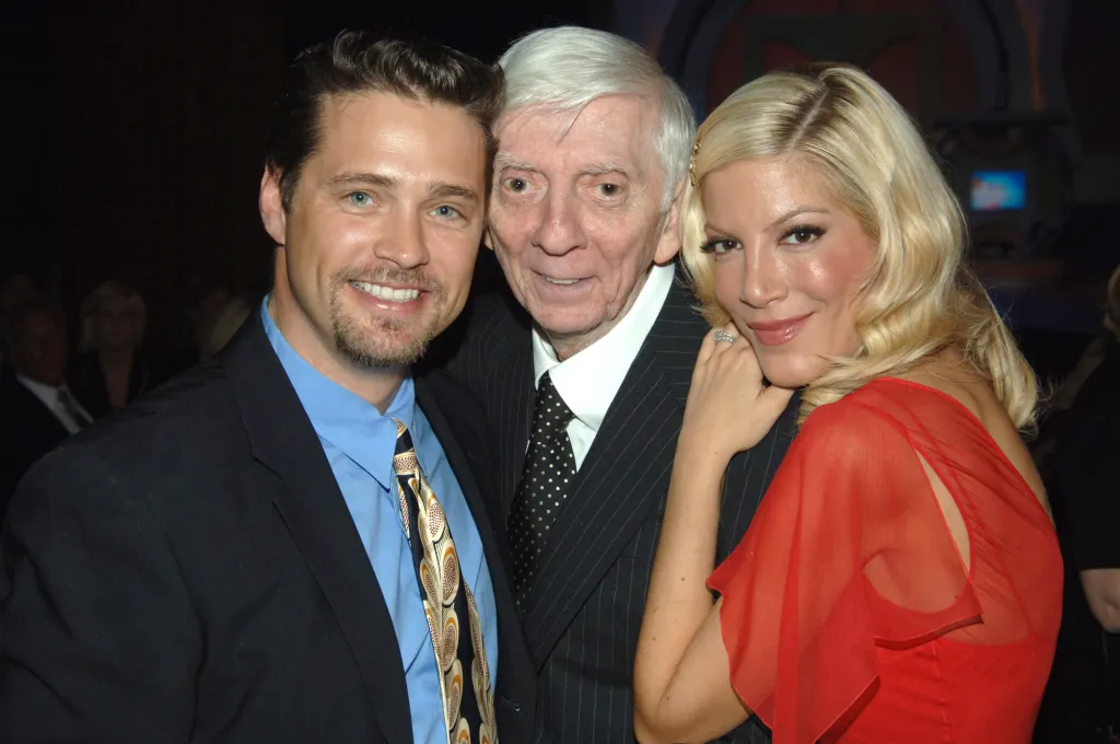 Jason Priestley, Aaron Spelling, and Tori Spelling pose together backstage.