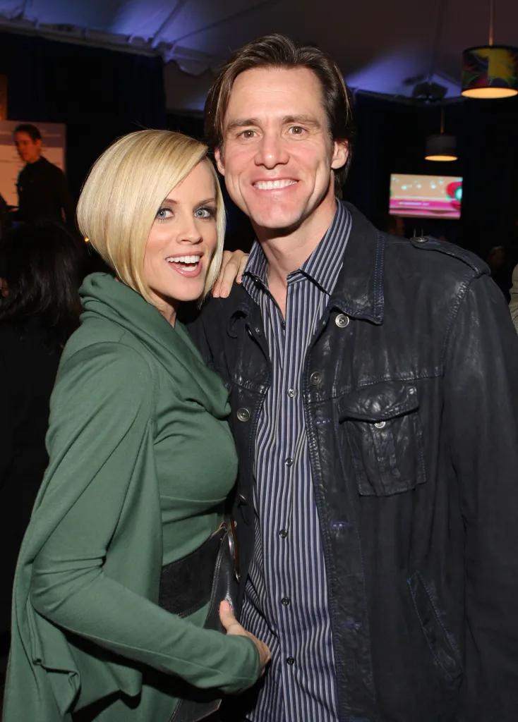 Jenny McCarthy and Jim Carrey smile together at a cocktail party.